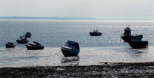 Shoebury beach with boats moored up in the water